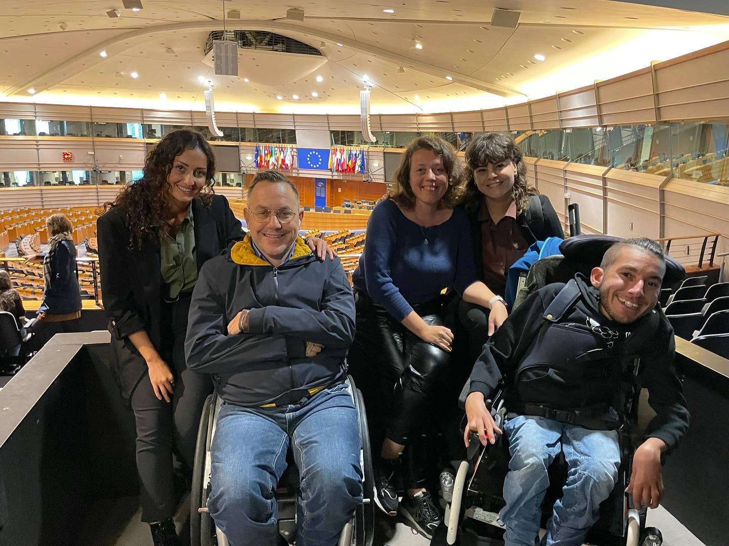 Group photo of 5 people in an enclosed space, European Parliament conference roomin Brussels. Looking at the camera hugging are Fotini Sarridou, Alexandros Taxildaris, Fenia Tsiakalou, Stella Argiropoulou and Spyros Dadanides.