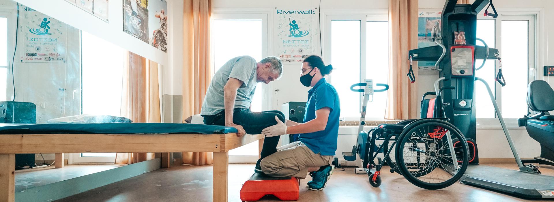 Cover. Disabled man excercising in a fully equipped gym with a "Perpato" occupational therapist.